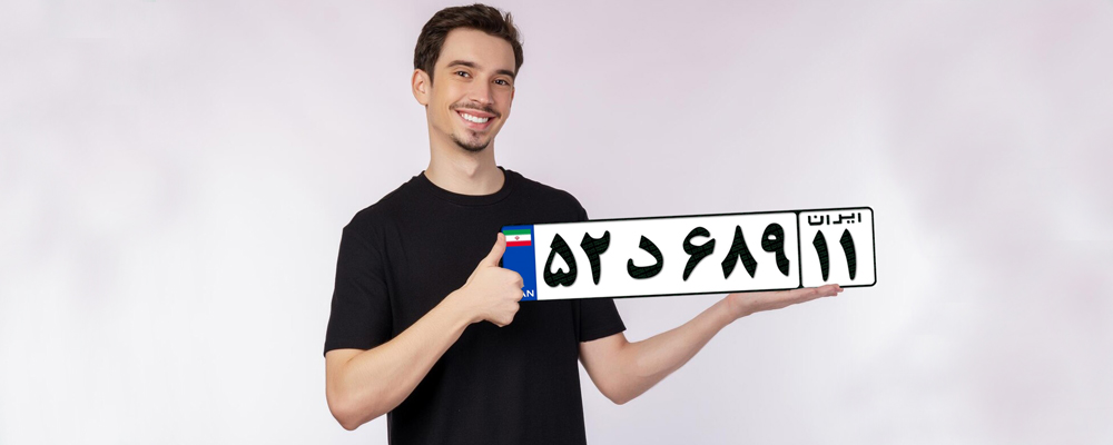 The copy of the license plate is in the hands of a young and smiling boy